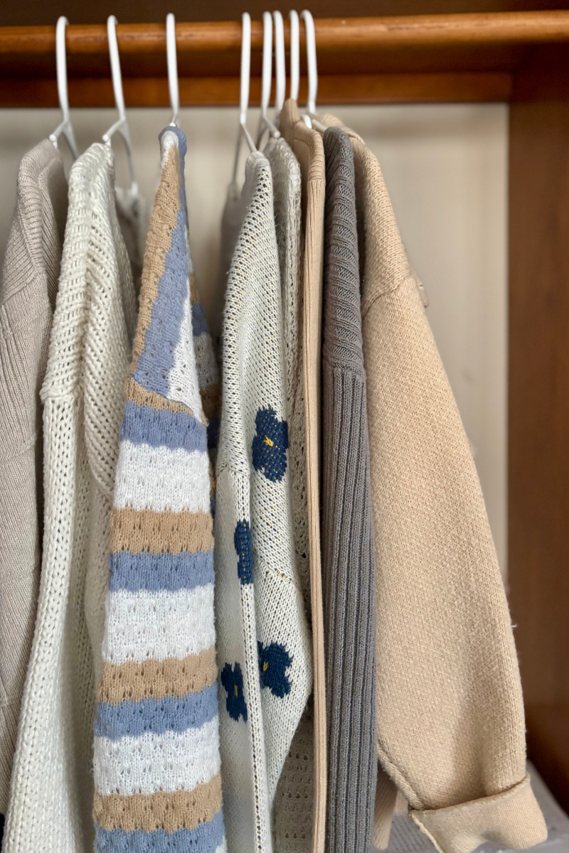 Sweaters hanging in decluttered closet
