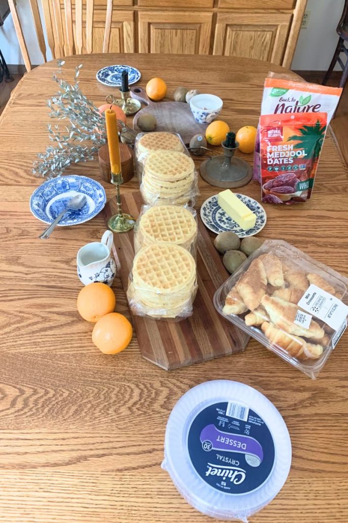 Table with various foods and fruits assembled for building charcuterie table scape